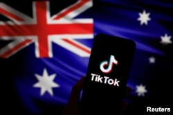 Logo aplikasi video TikTok milik Tiongkok terlihat pada telepon pintar di depan gambar bendera nasional Australia, 4 April 2023. (Foto: Tingshu Wang/Reuters)