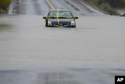 A car stranded on a flooded road due to a storm in Windsor, California, Thursday, November 21, 202. (Godofredo A.Vásquez/AP)