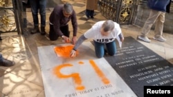 Aktivis iklim dari 'Just Stop Oil' melukis di atas makam naturalis Inggris Charles Darwin di Westminster Abbey di London, Inggris, 13 Januari 2025, dalam tangkapan layar yang diperoleh dari sebuah video. (Just Stop Oil/Jamie Lowe/Handout via REUTERS)